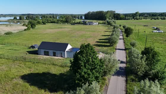 Droga asfaltowa prowadząca do działek w Marcelinie i nowy dom przy niej