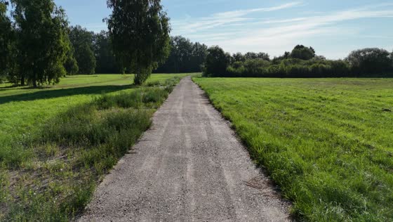 Film z drona: lot nad drogą gruntową prowadzącą przez działki w Marcelinie